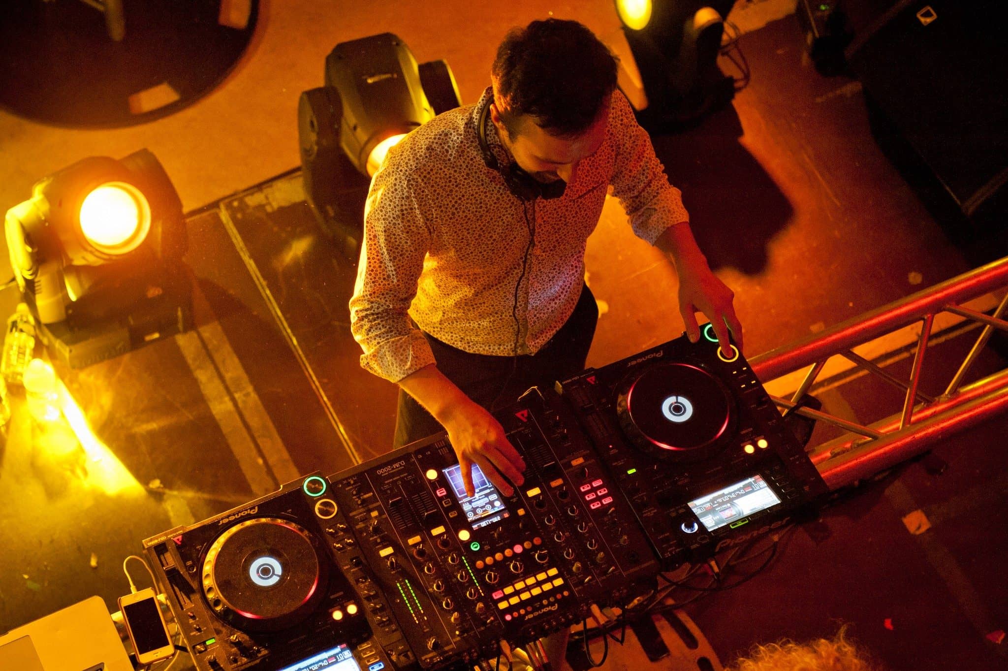 DJ aux platines vu d'en haut, entre les projecteurs