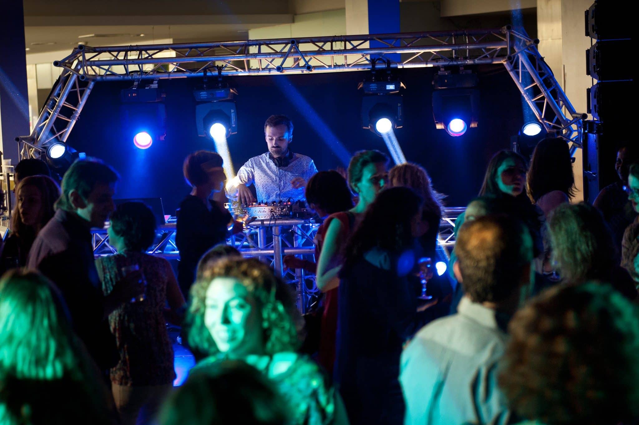 DJ sur une scène en structure, entouré du public