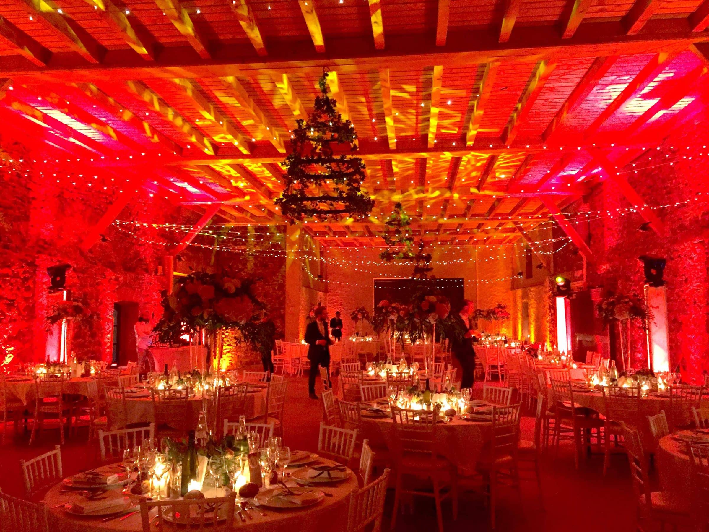 Salle de réception éclairée en rouge et or pour un dîner de mariage