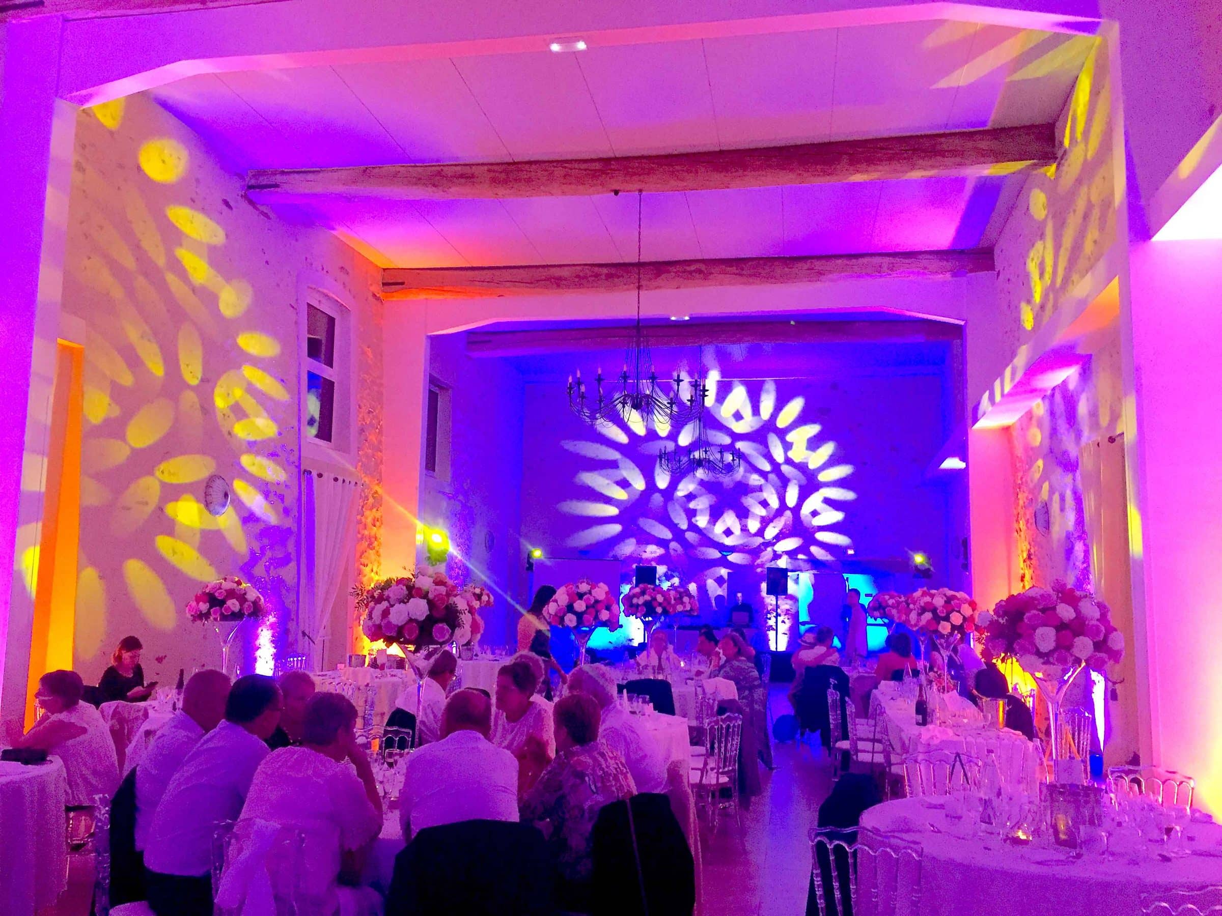 Dîner de mariage sous un éclairage violet et des motifs lumineux