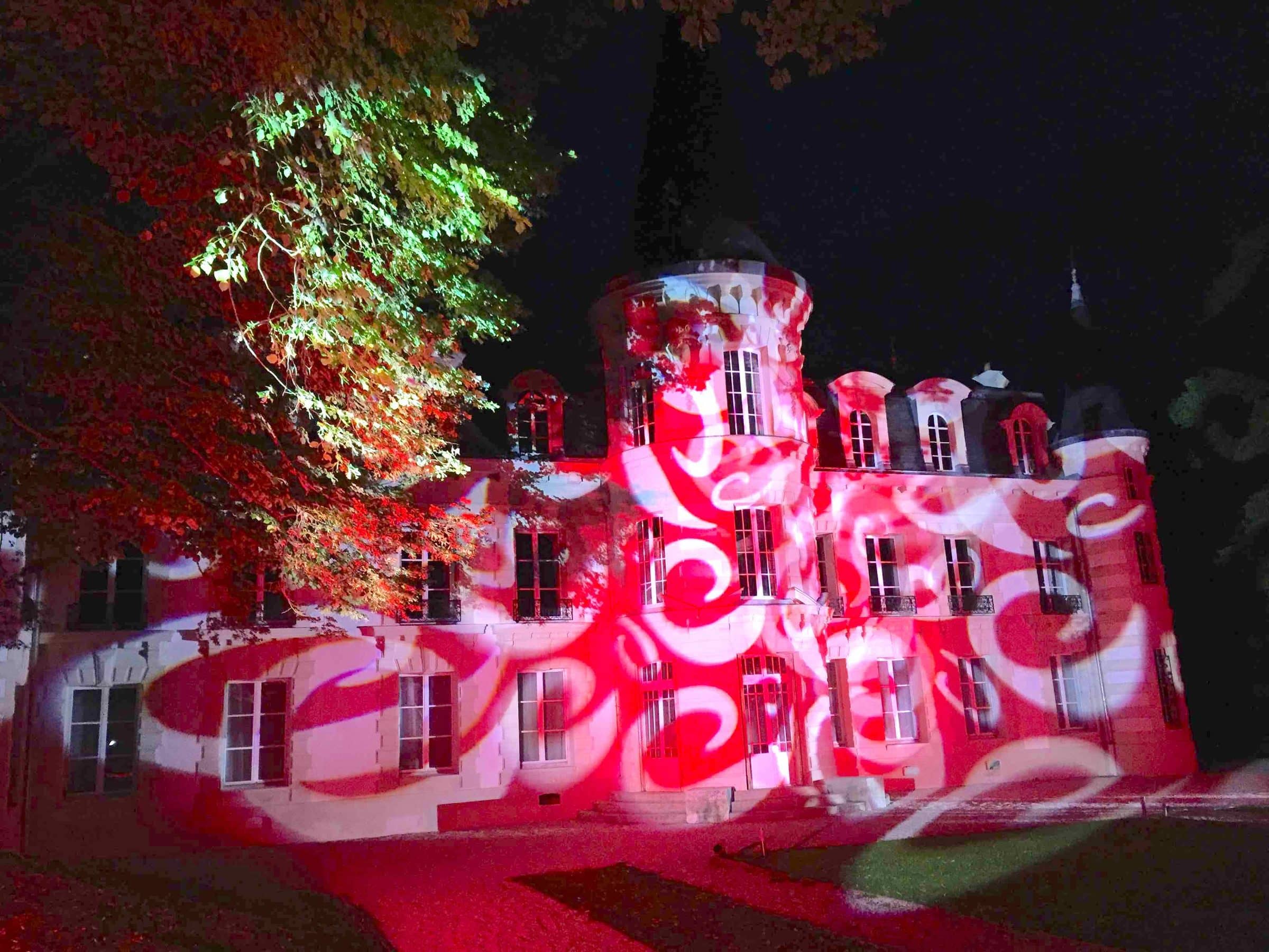 Façade de château habillée de projections lumineuses rouges