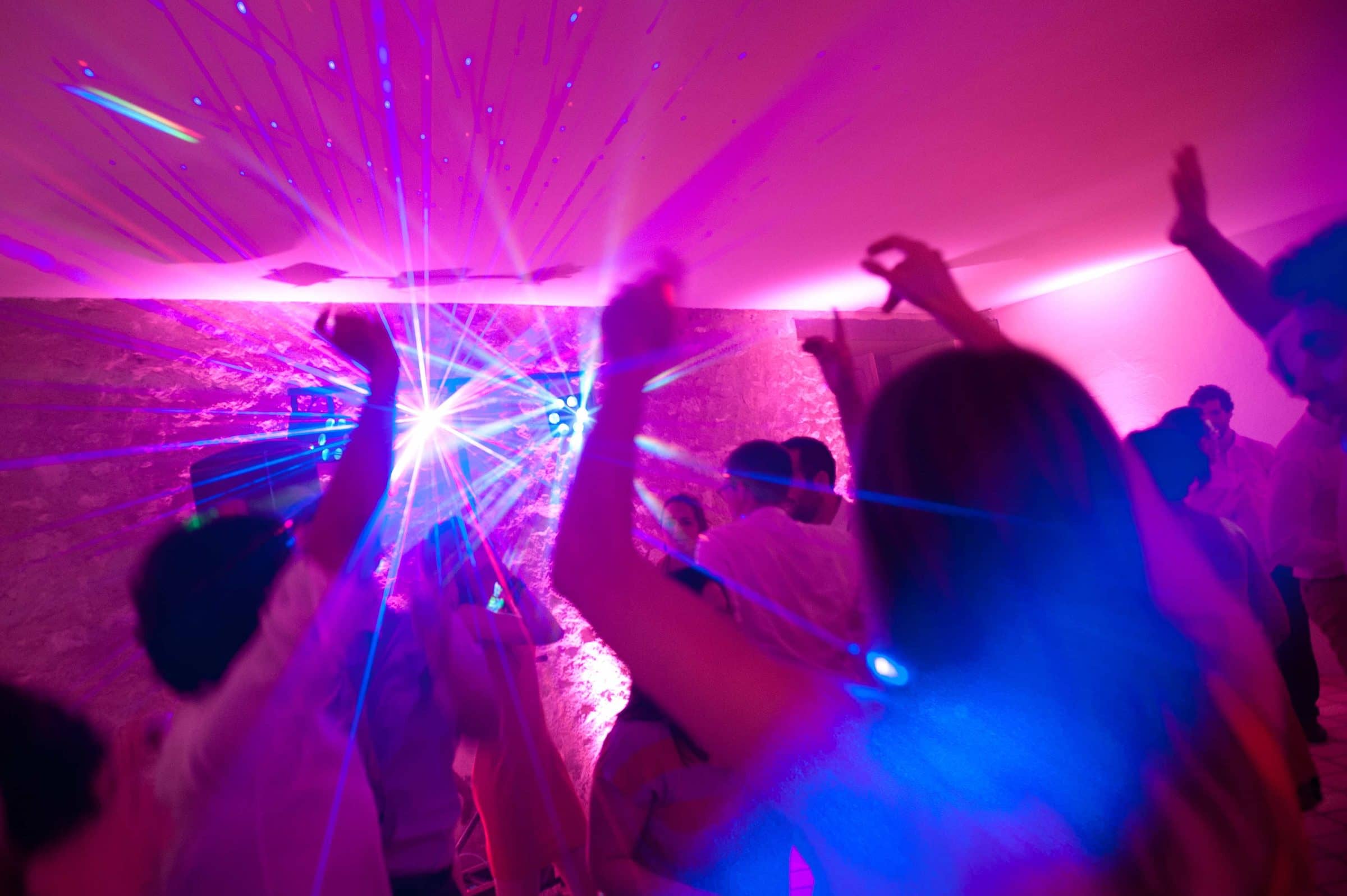 Invités qui dansent sous des lasers roses et bleus