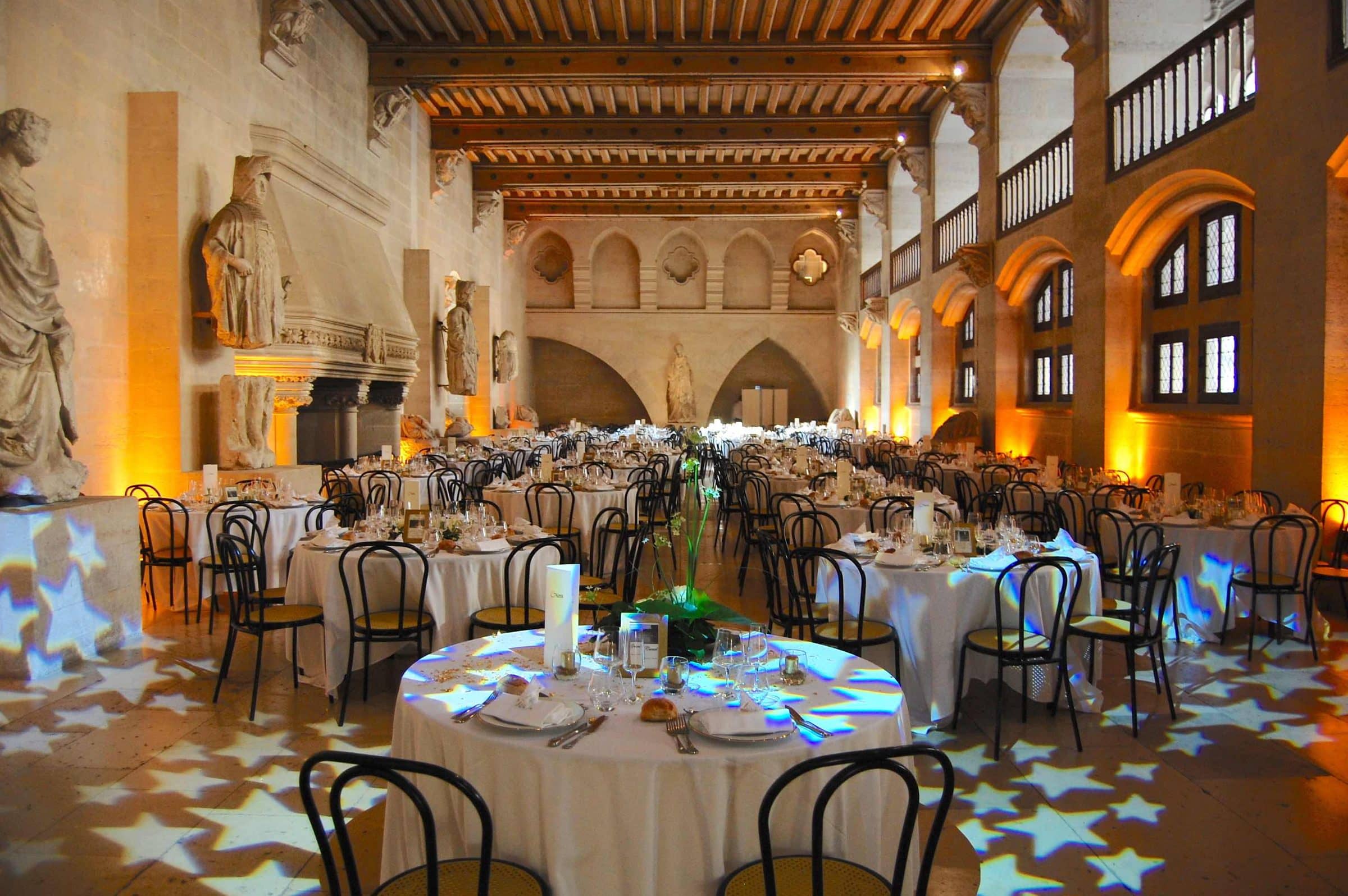 Dîner de mariage dans une salle gothique, étoiles projetées au sol