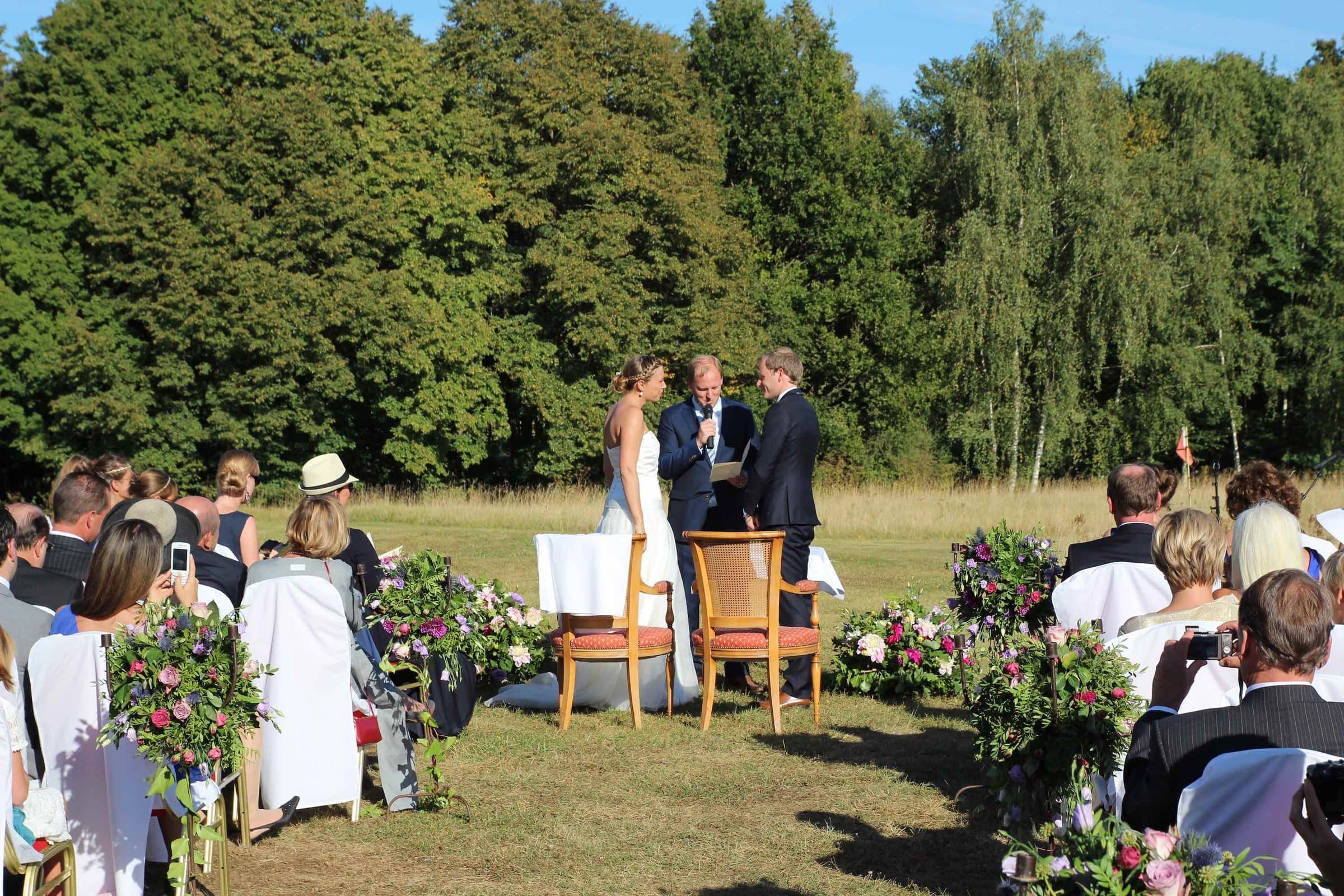 Celebrant-led ceremony in a meadow, with a microphone, in front of the guests