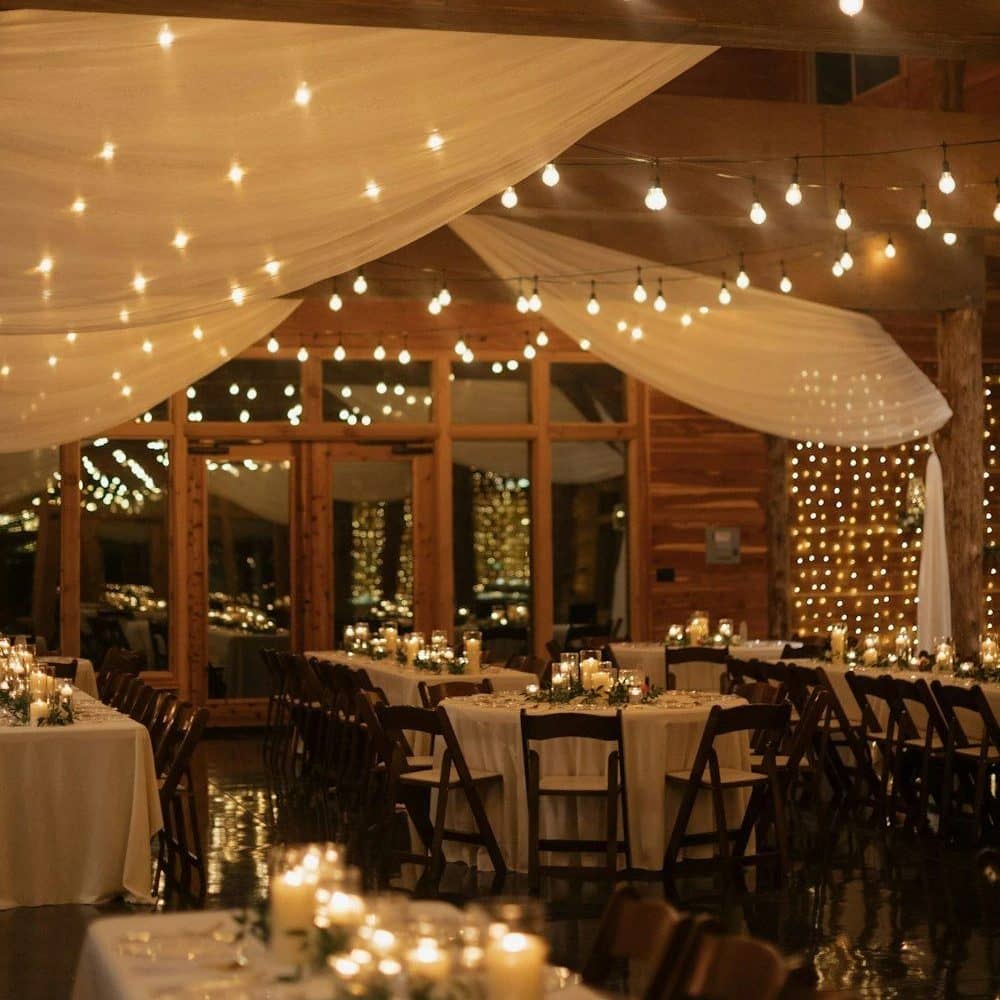 Festoon lights and drapes above a candlelit dinner