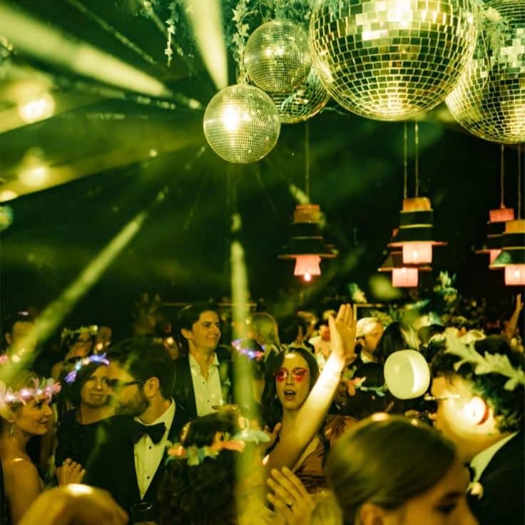 Invités dansant sous des boules à facettes et des lasers