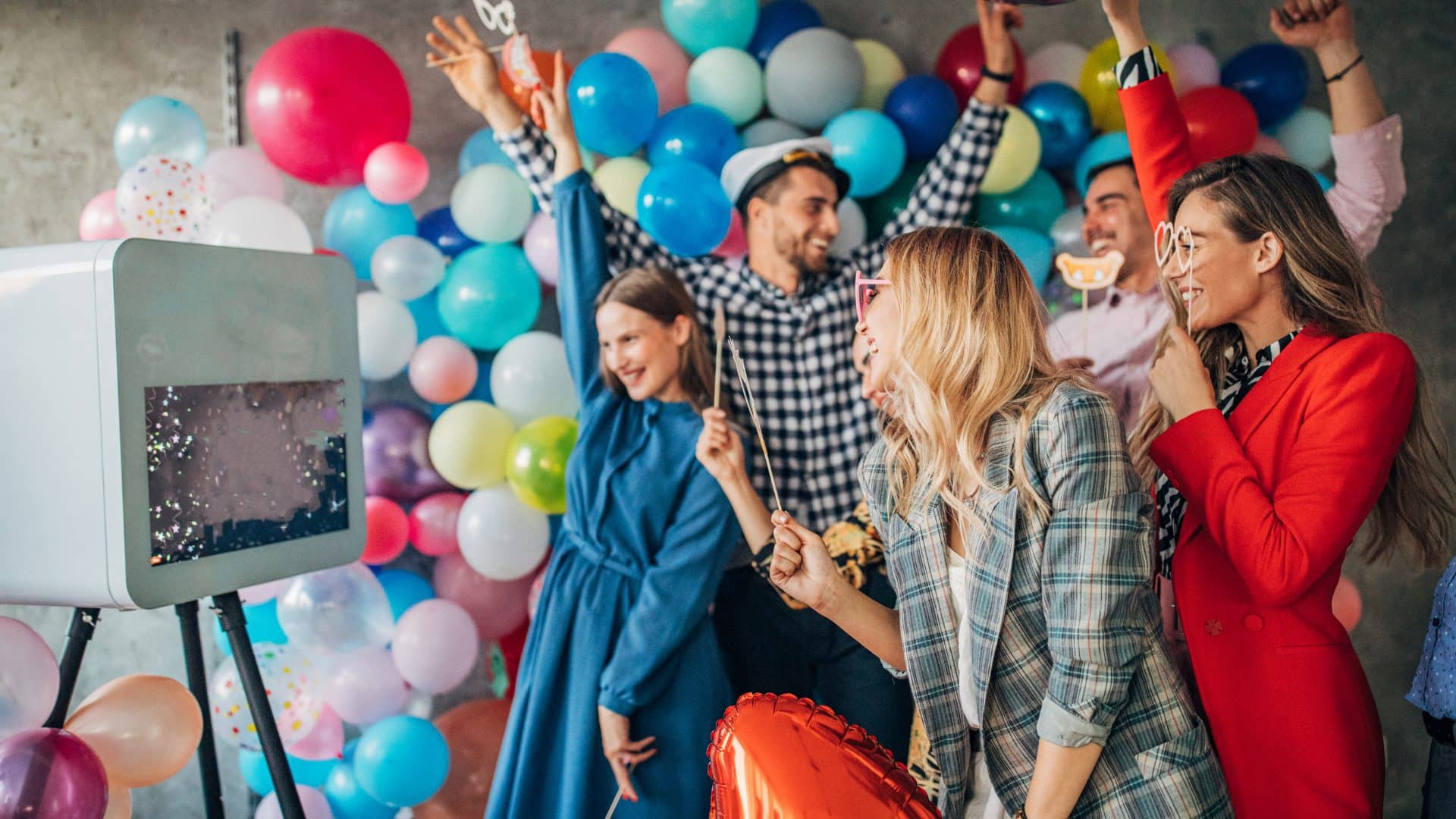Invités qui posent devant une borne photobooth