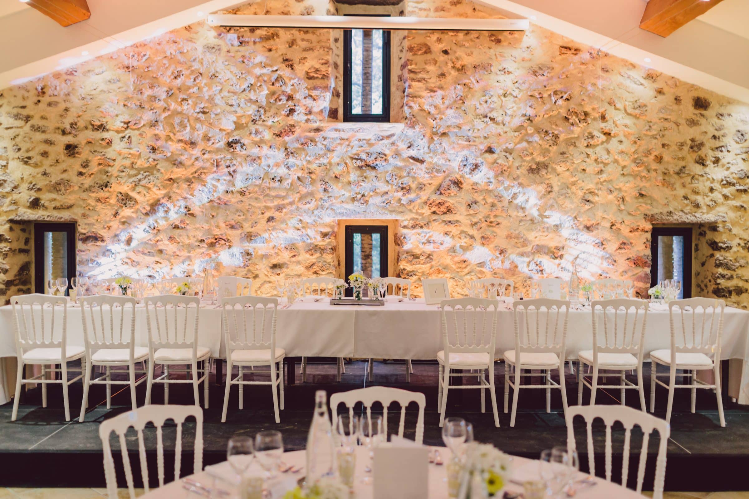 Salle de réception aux murs de pierre avec projection lumineuse