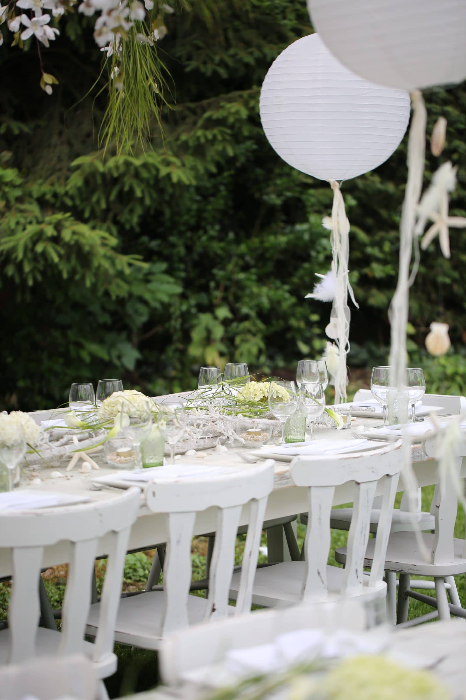 Tables blanches décorées de lanternes en papier