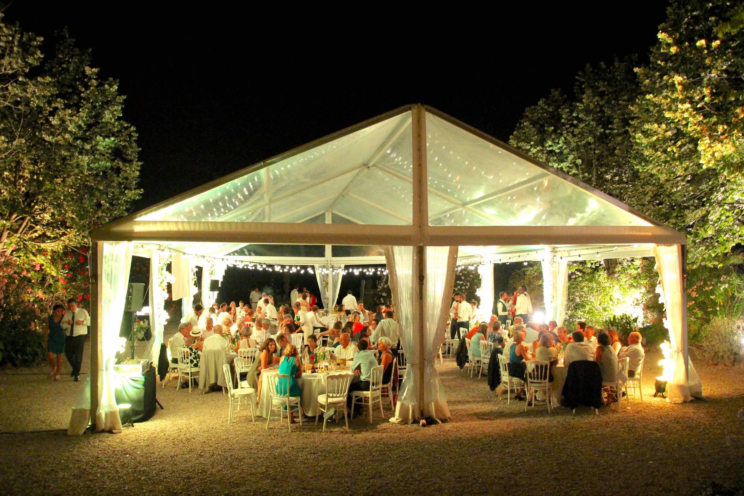 Marquee lit up at night, guests seated for dinner