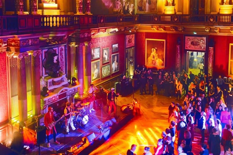 Salle de réception historique illuminée pendant une soirée dansante