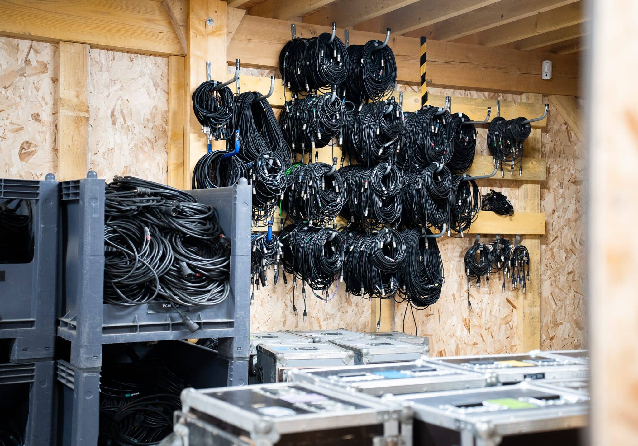 Câbles rangés et flight cases dans un atelier