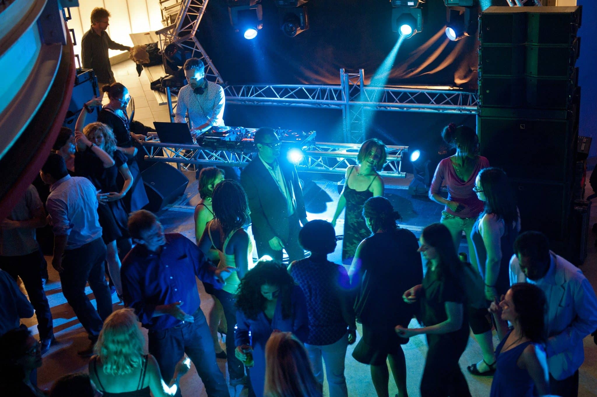 Invités dansant devant la régie DJ éclairée en bleu