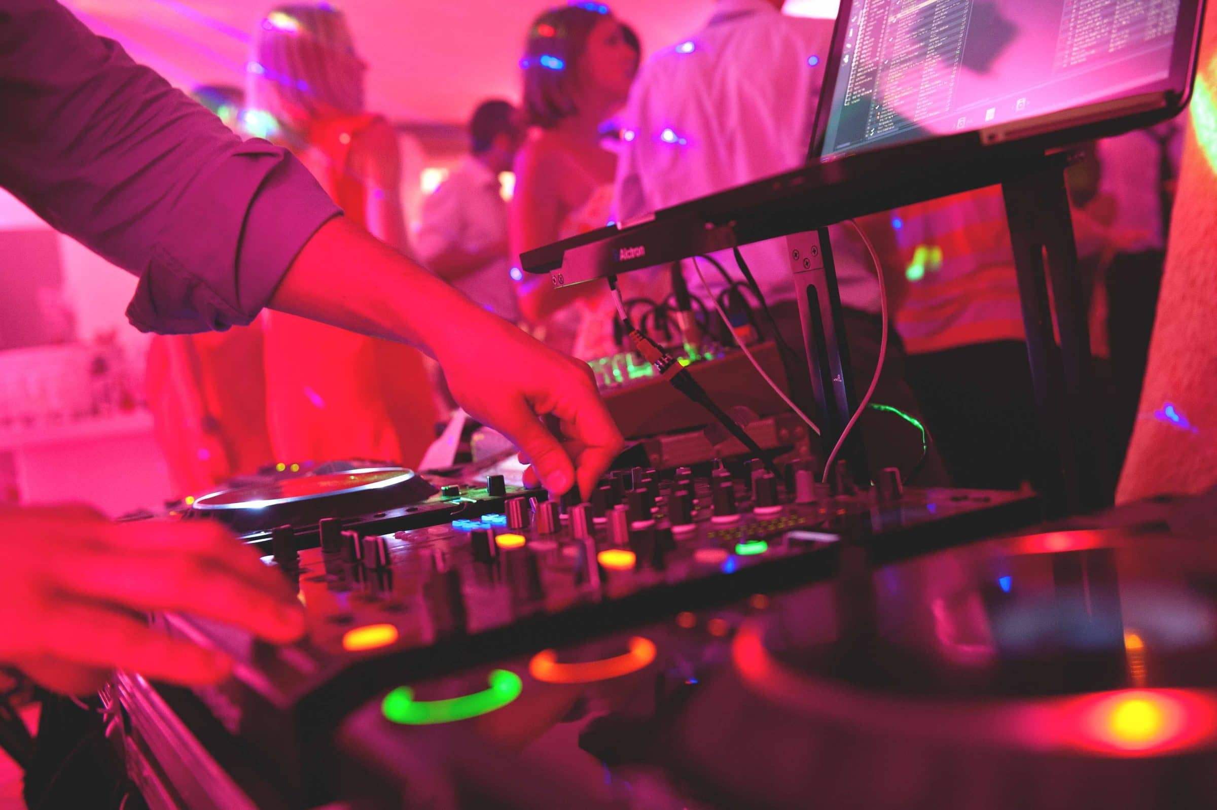 DJ aux platines dans une lumière rose